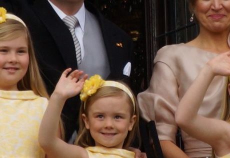 A royal family waving from the palace's balcony