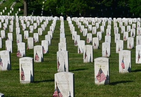 A cemetery with many neatly lined tombstones.