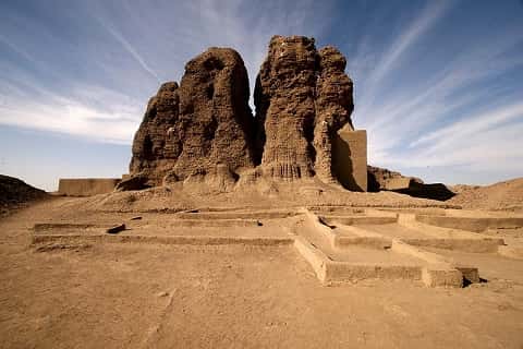 The desert. The ruins of a tower emerge from the sand.