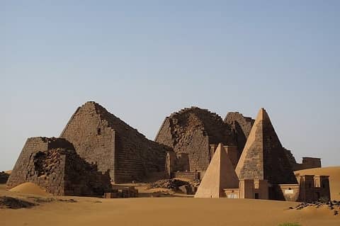 The desert. Two smaller pyramids in the front, four large pyramids in the back.