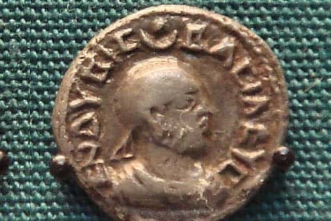 An ancient coin with a face on it.