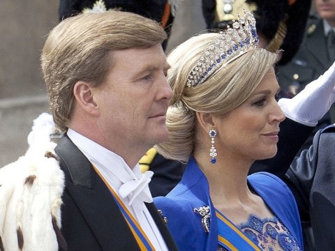 A man and a woman walking side by side dressed in royal regalia