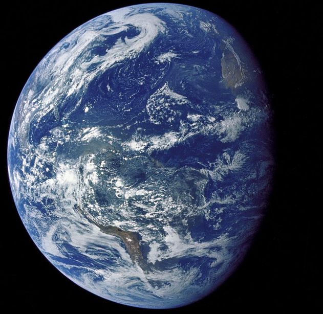 A picture of the Earth taken from deep space. The Earth looks like a blue ball with some white, green, and brown patches.