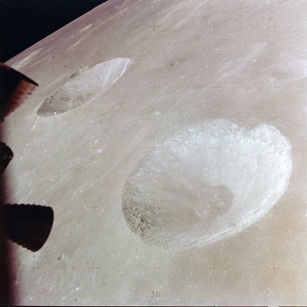 A close up of the Moon's surface. It is silver, smooth, and has two huge craters.