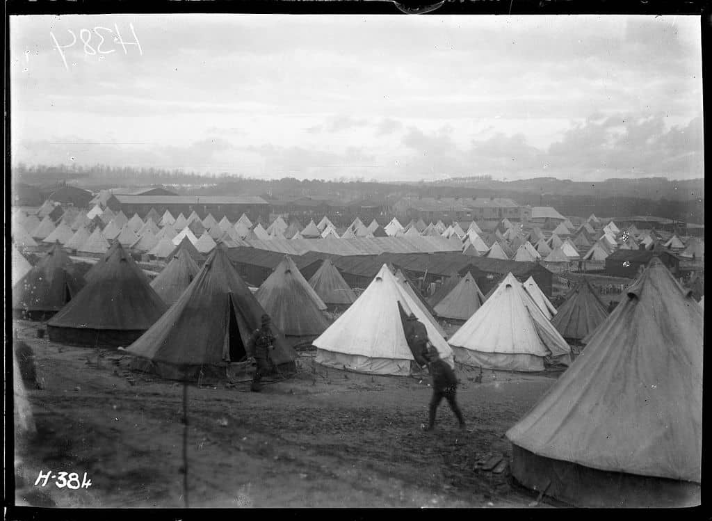 Panoramic view. Many white military tents cover the ground