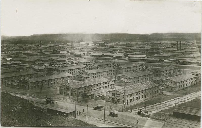 Panoramic view of what looks like a huge military town. It has rows of large wooden barracks.
