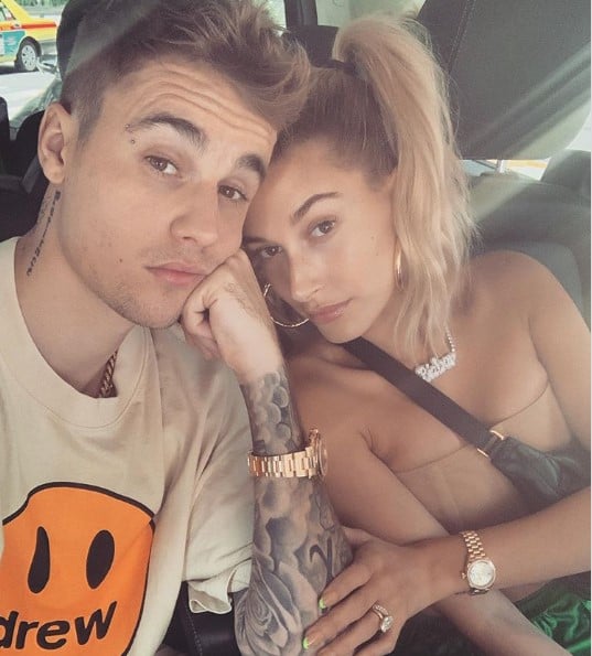Justin and Hailey posing, heads together, inside a car.