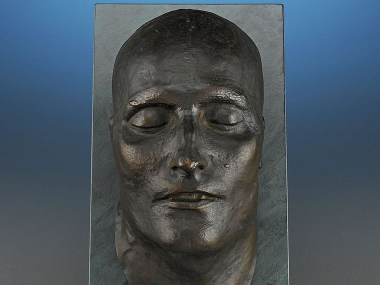 Napoleon's bronze death mask seen from the front. His face has an oval shape. He looks peaceful. His nose and lips are thin, he has high cheekbones, a medium-sized forehead, and eyebrows that sit just above the eyes.