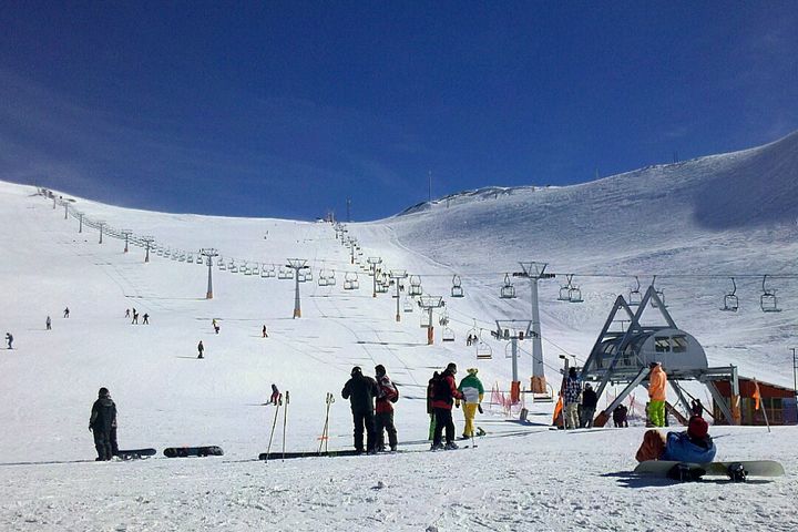 Slopes with people skiing. There is also a ski-lift.