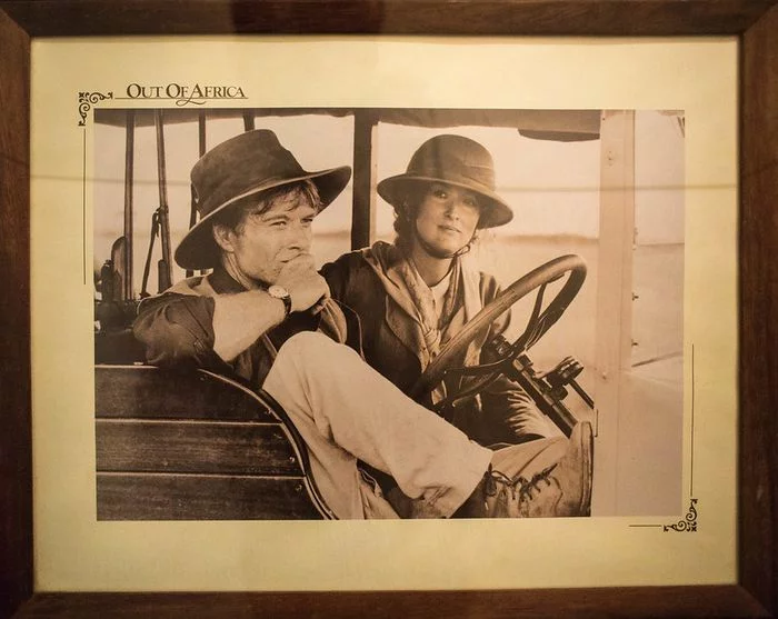 Black and white picture of Meryl Streep driving a jeep. Next to her, on the passenger seat, is Robert Redford.