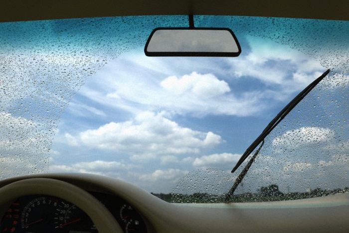 A windshield and the wiper seen from inside a car.