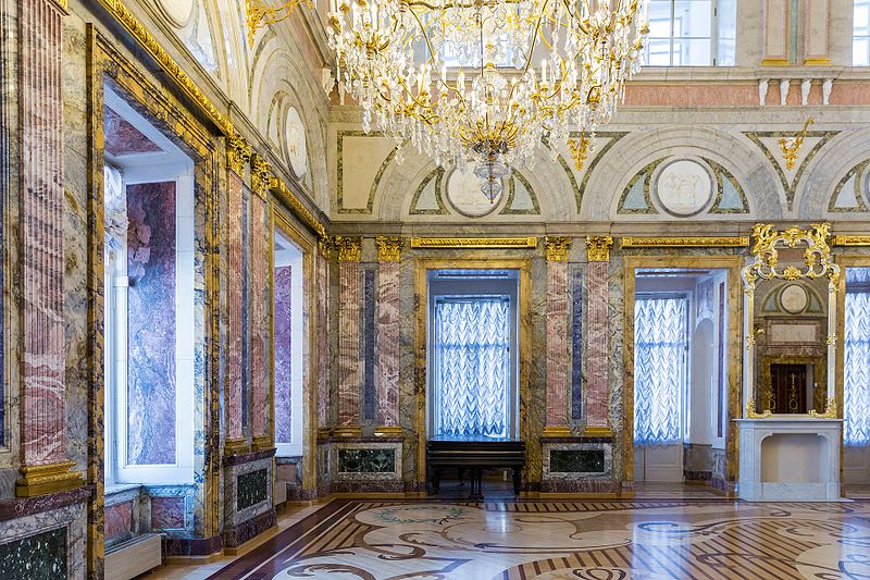 Inside a palace. The room is richly decorated with marbles of different colors. All the walls, ceiling, and floors are covered in marble.