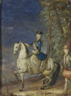 A young woman on horseback. She rides a white horse.