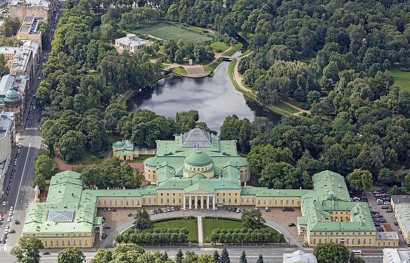 Aerial view of a sprawling palace surrounded by large gardens.